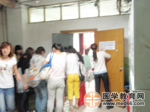 監(jiān)考老師正在查驗(yàn)衛(wèi)生資格考生的準(zhǔn)考證及證件