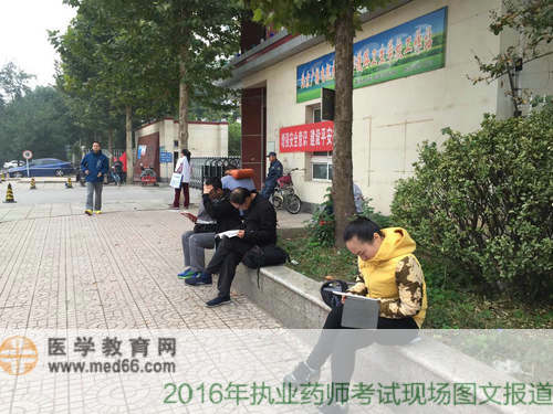臨近考試，在考場門口抓緊時間復習的考生