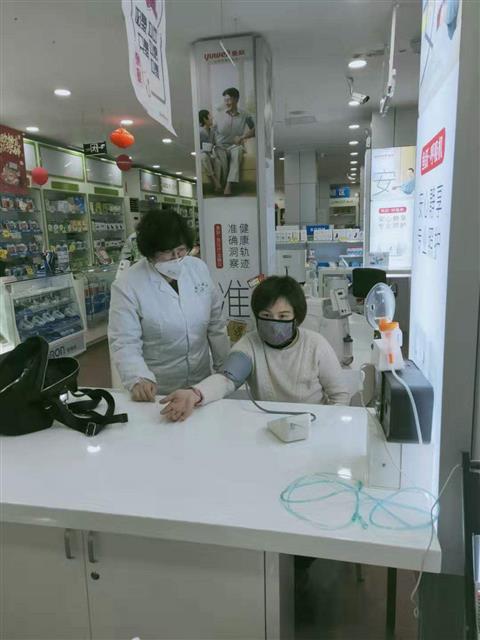 魏雪鴻為顧客測量血壓。